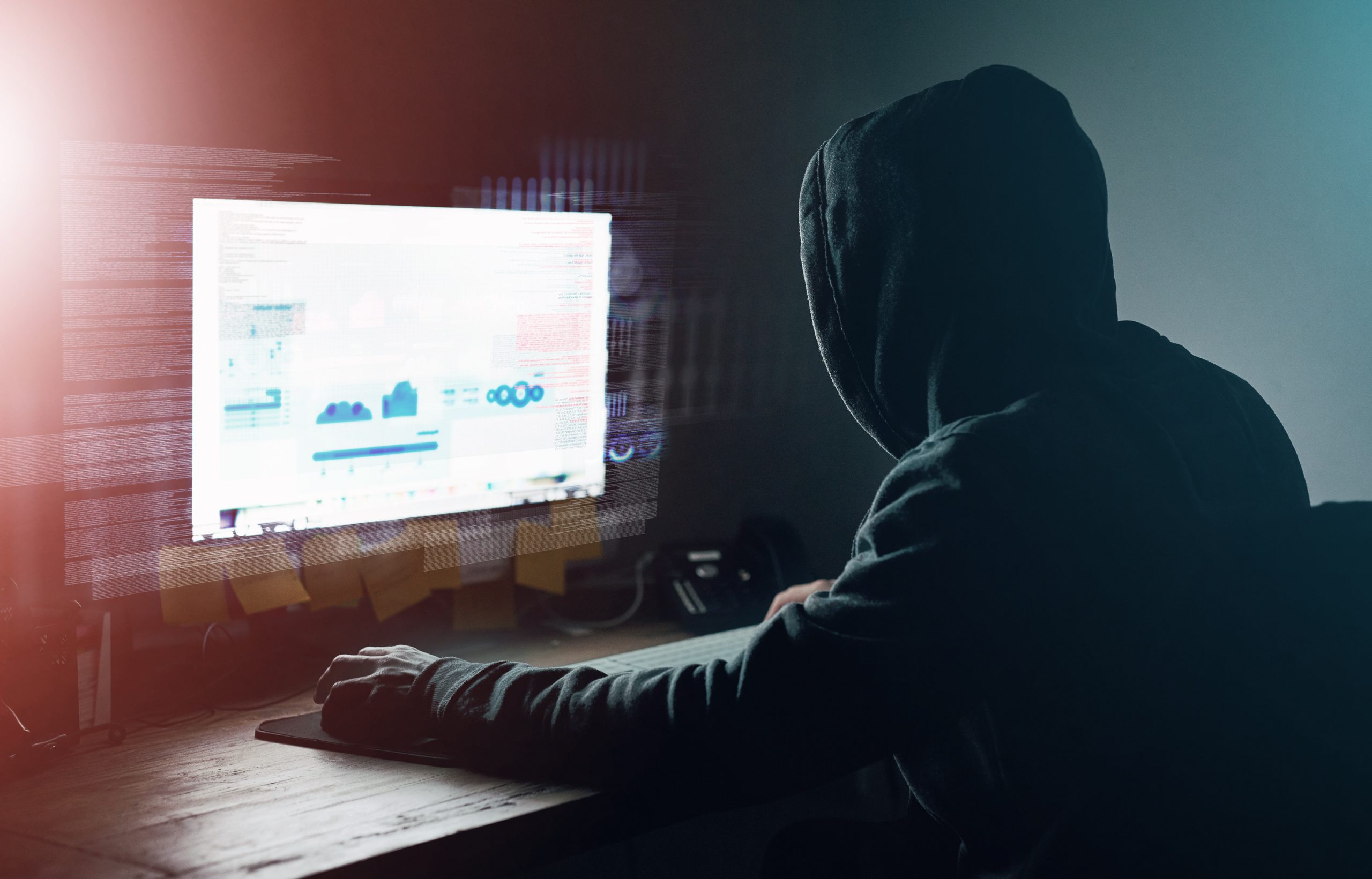 Dark, office and man at computer for hacking, online programming and cybersecurity at night. Software, developer or hacker in hoodie coding for password, firewall or network access for cyber attack.